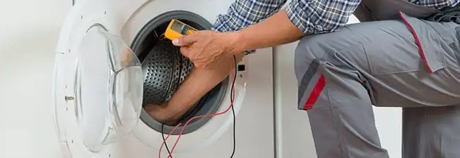 Dryer repair technician inspecting and repairing a clothes dryer in Philadelphia, PA
