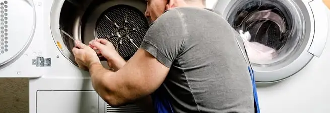 Dryer repair technician fixing a clothes dryer drum in Philadelphia, PA