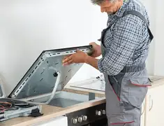 Appliance repair technician installing a built-in cooktop in Philadelphia, PA