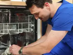 Dishwasher repair technician inspecting and servicing an open dishwasher in Philadelphia, PA