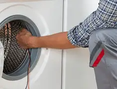 Dryer repair technician diagnosing and servicing a clothes dryer in Philadelphia, PA