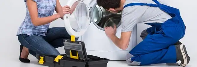 Washer repair technician inspecting a front-load washing machine with tools in Philadelphia, PA