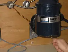 Garbage disposal repair technician tightening the mounting ring under a sink in Philadelphia, PA