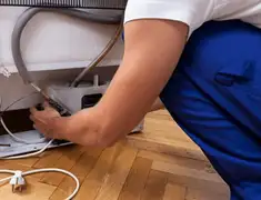 Appliance repair technician fixing refrigerator water line and connections in Philadelphia, PA