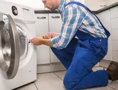 Washing machine repair technician servicing a front-load washer in Philadelphia, PA