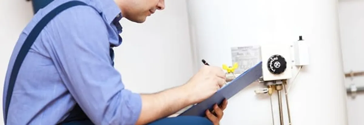 Water heater repair technician inspecting the unit and recording service notes in Philadelphia, PA