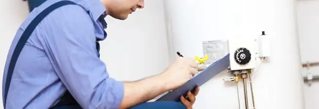 Water heater repair technician inspecting the unit and recording service notes in Philadelphia, PA