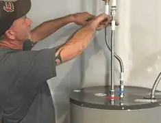 Water heater repair technician tightening supply line connections in Philadelphia, PA